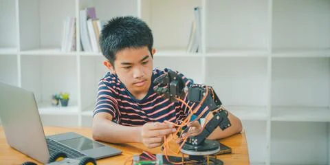Asian boy learning and studying the work of technology robots.homeschool an.. Stock Photos