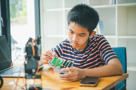 Asian boy learning and studying the work of technology robots.homeschool an.. Stock Photos