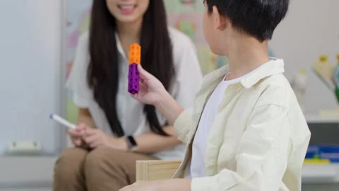 Asian Boy Learning Math with Plastic Counting Blocks and Private Tutor Stock Footage 330234718