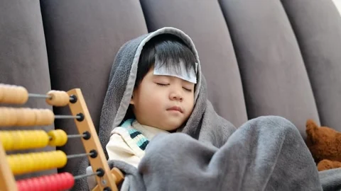 Asian boy Lying sick, he had a fever reducing patch on his forehead Stock Footage 252385898