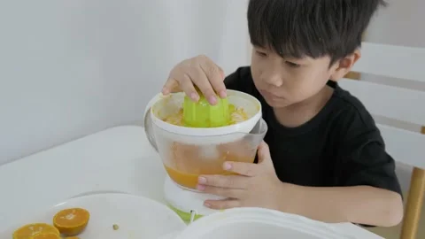 Asian boy making fresh orange juice. Stock Footage 153825517