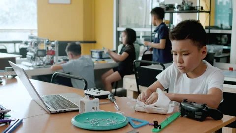 Asian boy making the robot arm. Group of schoolchildren interacting using Stock Footage 242446876