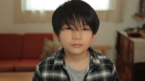 Asian boy opens his eyes and stares the camera. Unsatisfied. Dolly in. Stock Footage 221396440