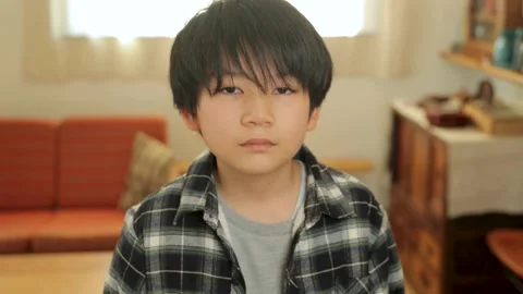 Asian boy opens his eyes and stares the camera. Dolly out. 25P. Stock Footage 224073298