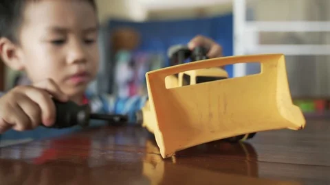 Asian boy play fixing construction machine toy Stock Footage 119697368