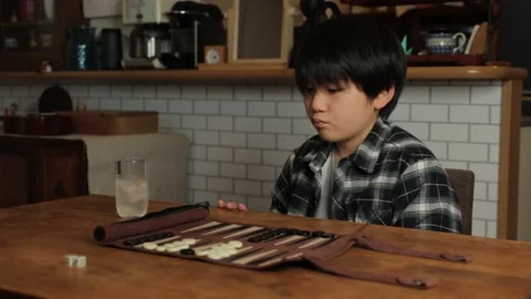 Asian boy playing backgammon at home. Stock Footage 221360788