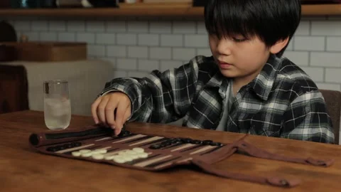 Asian boy playing backgammon at home. Stock Footage 221360957