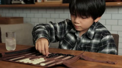 Asian boy playing backgammon at home. Stock Footage 224233598