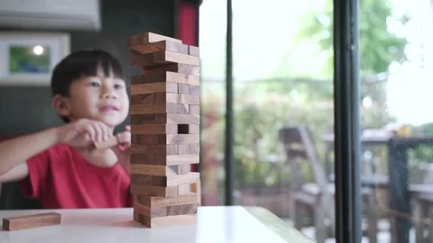 Asian boy playing building block tower by wooden brick Stock Footage 152290584