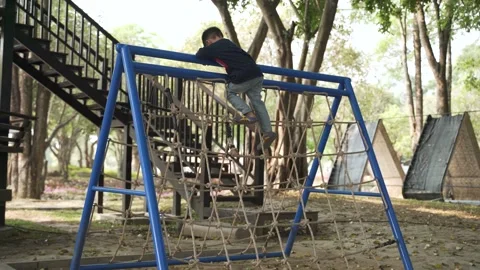 Asian boy playing climbing rope at kid playground Stock Footage 144676233
