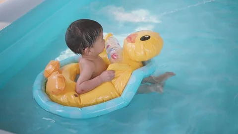 Asian boy playing with duck balloon in portable swimming water pool Video stock 88818988