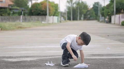 Asian boy playing with a folded paper airplane. Stock Footage 171782992