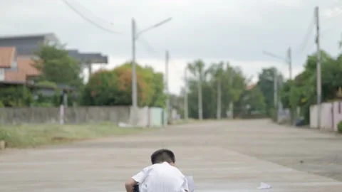 Asian boy playing with a folded paper airplane. Stock Footage 202259840