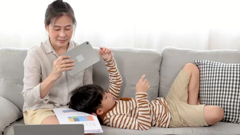 Asian boy playing game on tablet and feeling sleepy while lying down in his.. Stock Footage 249583788
