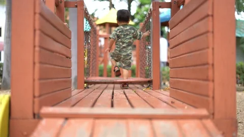 Asian boy playing at kid training playground, crossing a suspension bridge Video stock 88632148