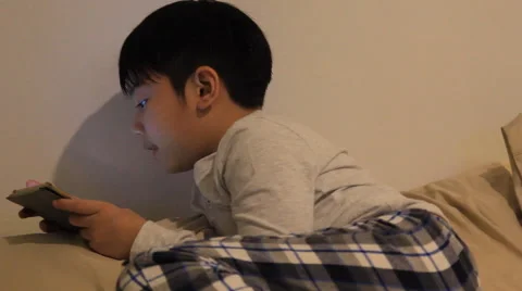 Asian boy playing smart phone in the room Stock-Footage 64231367