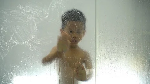 Asian boy playing with soap and water from shower head Stock Footage 118238941