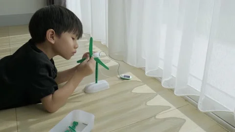 Asian boy playing solar cell toy. Vídeos de archivo 153825216