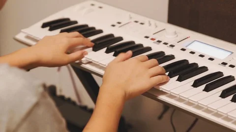 Asian boy practicing piano at home on white electric piano Stock Footage 107936596