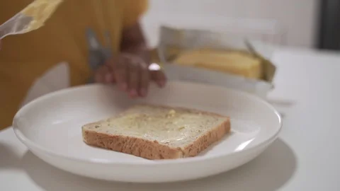 Asian boy putting butter on the bread Video stock 127368593