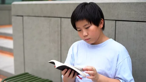 Asian Boy reading and study a book, the bible 4K Stock Footage 139566634