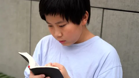 Asian Boy reading and study a book, the bible 4K Stock Footage 139566656