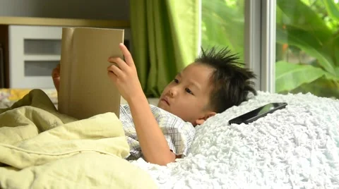 Asian boy reading book on the bed and sleep Stock Footage 53355904