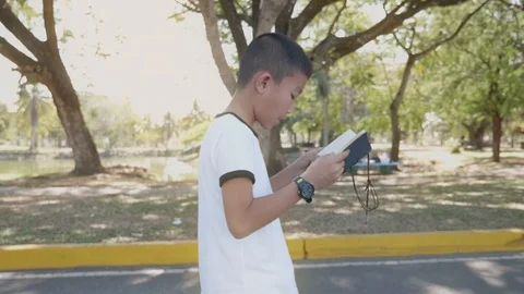 Asian boy reading a book  in the park. Stock Footage 127182016