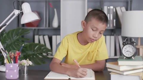 Asian boy sneezing while writing in the room. Stock Footage 157985754