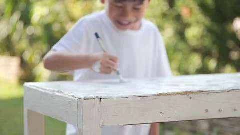 Asian boy using brush and white color for repairing old shelves. Stock Footage 168853111