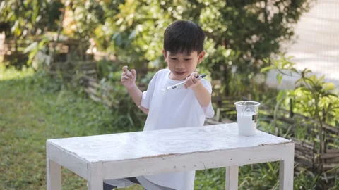 Asian boy using brush and white color for repairing old shelves. Video stock 171783024