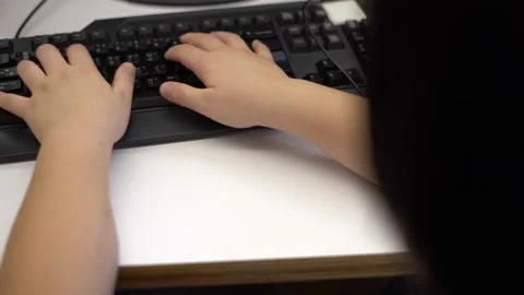 Asian Boy using a computer desktop playing 4K Stock Footage 139566220