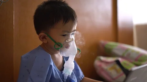Asian boy using inhaler containing medicine to stop coughing 스톡 동영상 95186944