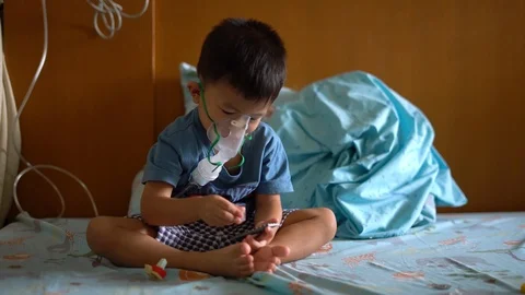 Asian boy using inhaler containing medicine to stop coughing Video stock 117264814