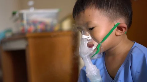 Asian boy using inhaler containing medicine to stop coughing Video stock 117264861