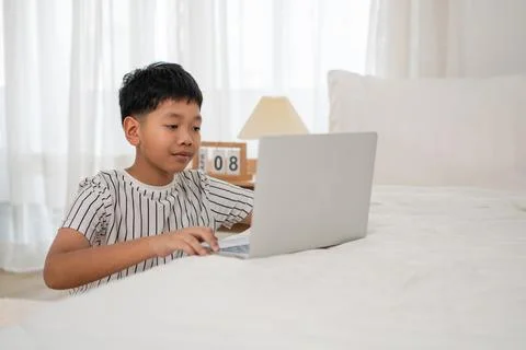 Asian boy using laptop to do homework at home Stock Photos