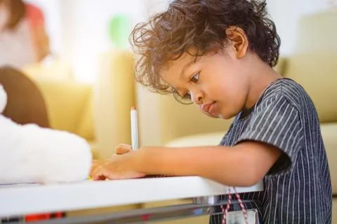 Asian boy using a magic pen to writing on notebook and afternoon light Stock Photos