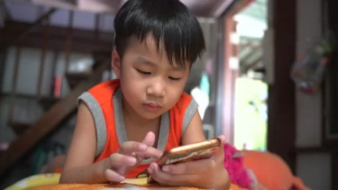 Asian boy using mobile phone to play game only one Stock Footage 133647111