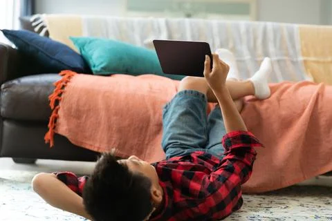 Asian boy using tablet with blank screen lying on floor at home Stock Photos
