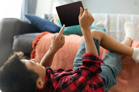 Asian boy using tablet with blank screen lying on floor at home Stock Photos
