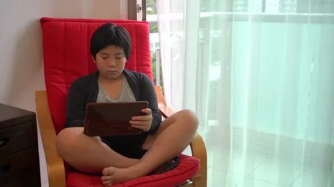 Asian Boy using tablet computer and sit at home 4K Stock Footage 139567114