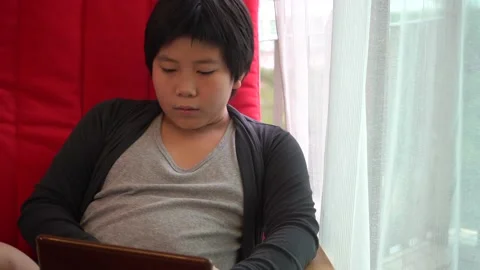 Asian Boy using tablet computer and sit at home 4K Stock Footage 139567125