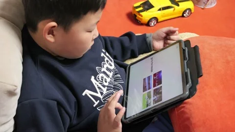 An Asian boy is using a tablet to study English 스톡 동영상 266429135