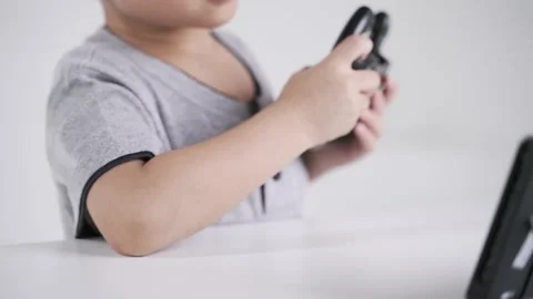 Asian boy using wheel controller for playing the racing video game Stock Footage 171782756