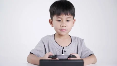 Asian boy using a wireless controller for playing a video game Video stock 151254953