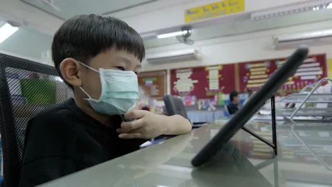 Asian boy watching computer tablet with a medical face mask. Stock Footage 154346752