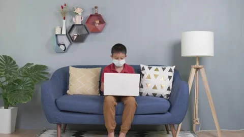 Asian boy wears sweater using computer laptop working from home Stock Footage 156091994