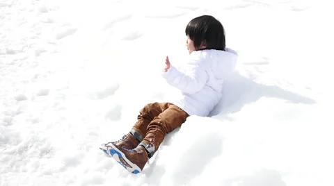 Asian boy in winter clothes playing with snow Stock Footage 60983623