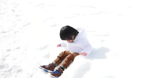 Asian boy in winter clothes playing with snow Stock Footage 60986687
