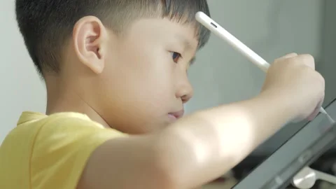 Asian boy writing a letter on a computer tablet with the electric pen. Stock Footage 179513908